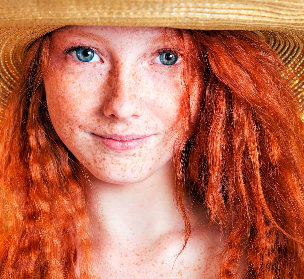 Femme rousse avec un chapeau de paille