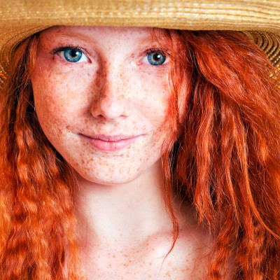 Femme rousse avec un chapeau de paille