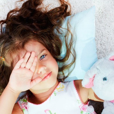 Petite filles dans un lit avec un doudou